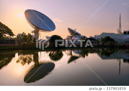 Large satellite dish antenna station by pond at dawn, Bangkok Large satellite dish antenna station by pond at dawn, Bangkok 137903859
