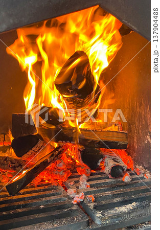 A vibrant image of burning firewood in a smoker creates a warm and inviting atmosphere. A vibrant image of burning firewood in a smoker creates a warm and inviting atmosphere. 137904488