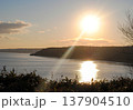The photograph captures a breathtaking view of a sea bay and autumn forest on the Kuril Islands during sunset on a sunny day. 137904510