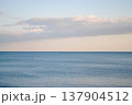 The photograph showcases a stunning view of a sea bay on the Kuril Islands at sunset, with vessels gently resting on the water. 137904512
