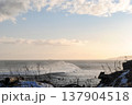 The breathtaking coastline of a Kuril Islands bay glistens at sunset on a sunny winter day. 137904518