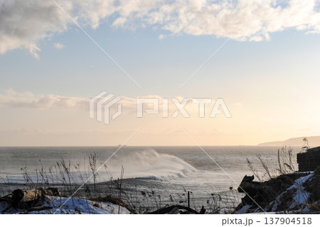 The breathtaking coastline of a Kuril Islands bay glistens at sunset on a sunny winter day. The breathtaking coastline of a Kuril Islands bay glistens at sunset on a sunny winter day. 137904518