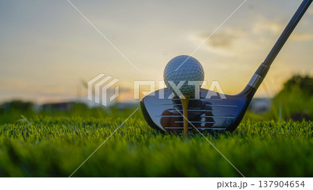 Golf clubs and balls on a green lawn in a beautiful golf course with morning sunshine. 137904654