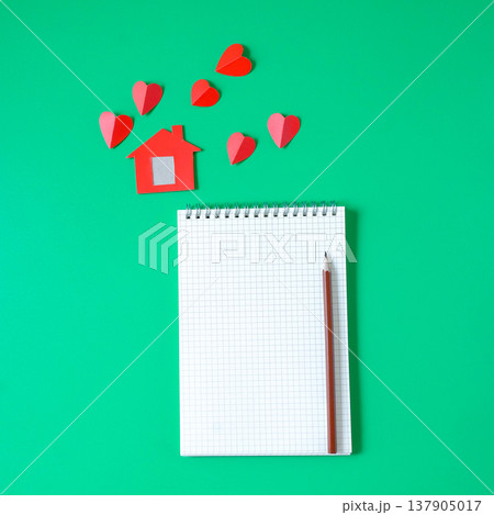 Minimal red house with blank book note and pencil . 137905017