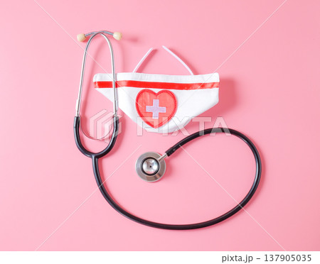 Stethoscope with nurse hat on color background. 137905035