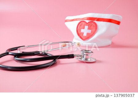 Stethoscope with nurse hat on color background. 137905037