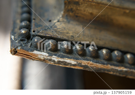 Close View of an Old Wooden Frame With Metal Detailing Showing Wear and Age From Years of Use in a Historical Setting 137905159