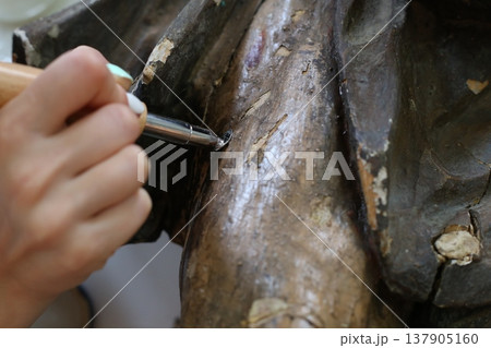 Restoration Process of a Wooden Canvas Fragment Using Ultraviolet Light Techniques in an Art Conservation Studio 137905160