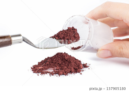 Brown Powder Substance Sits in a Pile on a White Background for Culinary Use 137905180
