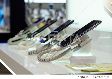 Showcase with smartphones in the modern electronics store. Buy a mobile phone. Many smartphones on the shelf of the technology store 137905606