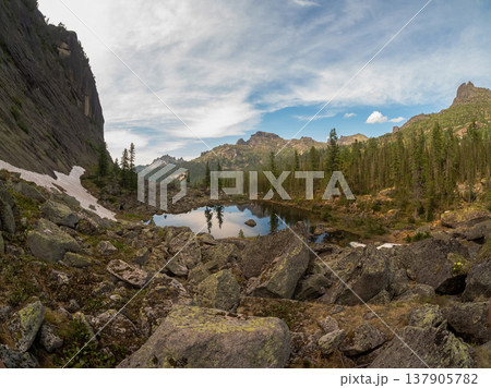 Mountain lake mirrors sky and peaks Mountain lake mirrors sky and peaks 137905782