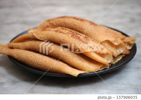 Side View of Traditional Bengali Sweet Patisapta Pitha Served on a Black Plate Side View of Traditional Bengali Sweet Patisapta Pitha Served on a Black Plate 137906035