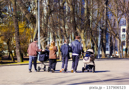 Belarus.Minsk, Two married couples with strollers on a walk in the park Belarus.Minsk, Two married couples with strollers on a walk in the park 137906523