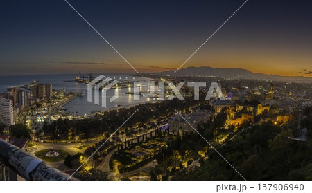 View of Malaga at sunset with city lights and calm waters of the port 137906940