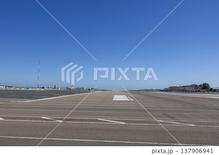 Gibraltar airport runway with clear blue sky and no visible aircraft or activity during the day Gibraltar airport runway with clear blue sky and no visible aircraft or activity during the day 137906941
