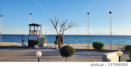 A seaside beach with a clean strip of sand and calm blue water 137906988