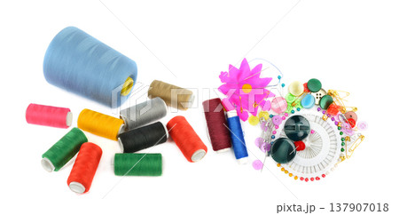 Comprehensive sewing kit with colorful thread spools, buttons, pins, and needles isolated on a white background. Top view of essential tailor tools and dressmaking accessories for DIY crafts. 137907018
