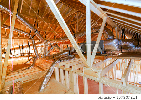 Ductwork installation in unfinished attic of residential building during construction 137907211