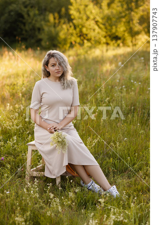 Peaceful Woman With Sunshine Surroundings. Tranquil Lady Basking In Bright Floral Glow 137907743