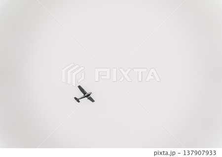 Small ultralight airplane with overhead wing and single propeller flying in sunset sky. 137907933