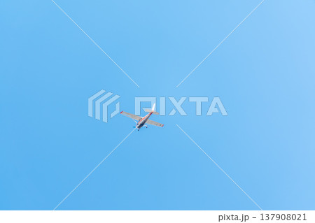 Small ultralight airplane with overhead wing and single propeller flying in sunset sky. 137908021