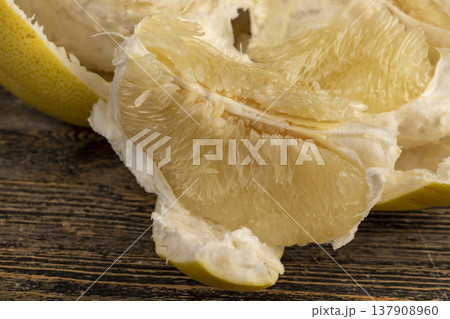 thick peel and soft juicy flesh of ripe grapefruit, sweet fresh grapefruit peeled from the yellow thick peel 137908960