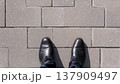 足元視点で見る石畳の歩道と黒い革靴のビジネスイメージ 137909497