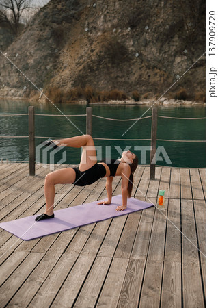 Attractive Woman Performing Advanced Yoga Pose Outdoors At Lake. Strength And Flexibility Training Concept Attractive Woman Performing Advanced Yoga Pose Outdoors At Lake. Strength And Flexibility Training Concept 137909720