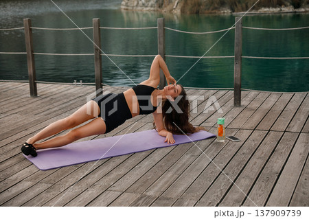 Pretty Woman Practicing Side Plank Yoga Pose Outdoors At Lake. Core Strength And Stability Concept 137909739