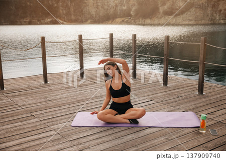 Beautiful Woman Practicing Seated Yoga Stretch Outdoors At Lake. Flexibility And Relaxation Concept Beautiful Woman Practicing Seated Yoga Stretch Outdoors At Lake. Flexibility And Relaxation Concept 137909740