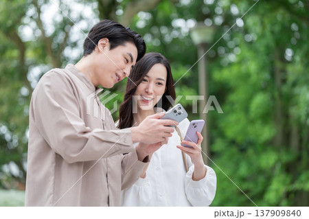 屋外でスマホを見る男女カップル 137909840