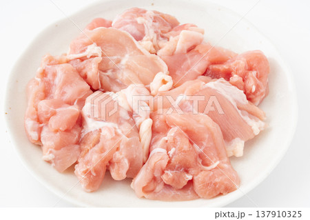お皿に載せたぶつ切りにした生の鶏もも肉のクローズアップ 137910325