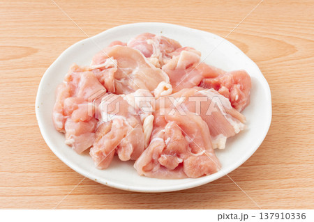 お皿に載せた生の鶏もも肉のぶつ切り お皿に載せた生の鶏もも肉のぶつ切り 137910336