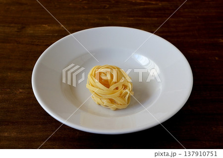 テーブル背景の乾麺のタリアテッレ 137910751
