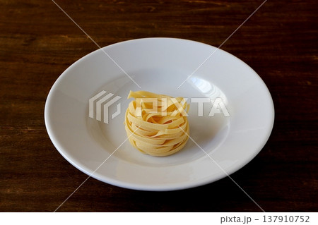 テーブル背景の乾麺のタリアテッレ 137910752