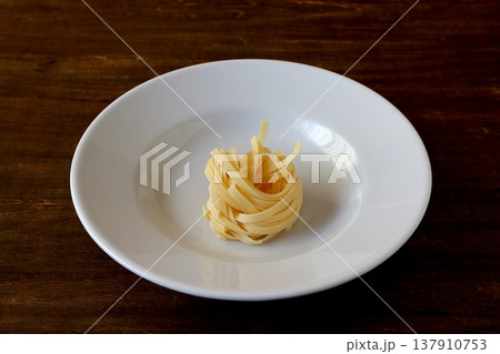テーブル背景の乾麺のタリアテッレ 137910753