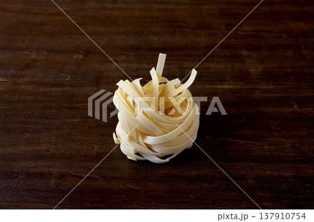 テーブル背景の乾麺のタリアテッレ 137910754