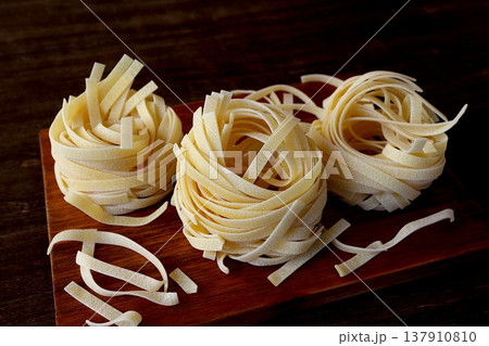 テーブル背景の乾麺のタリアテッレ 137910810