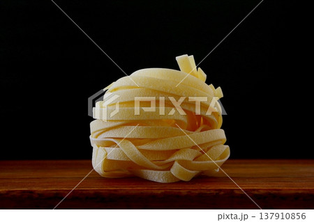 黒背景の乾麺のタリアテッレ 137910856