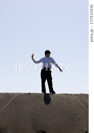 砂の上に立つ男性のシルエット 137910936