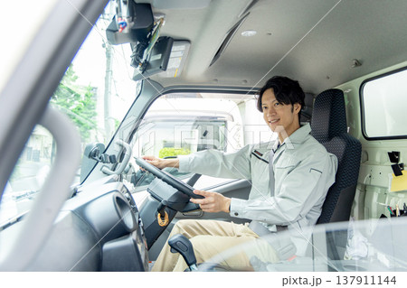 トラックに乗る作業着の男性 137911144