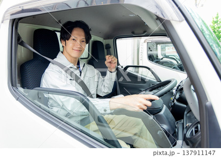 トラックに乗る作業着の男性 137911147