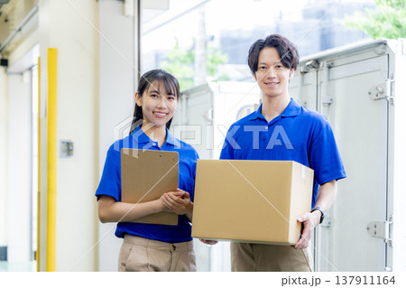 荷物を届ける宅急便の男女 137911164