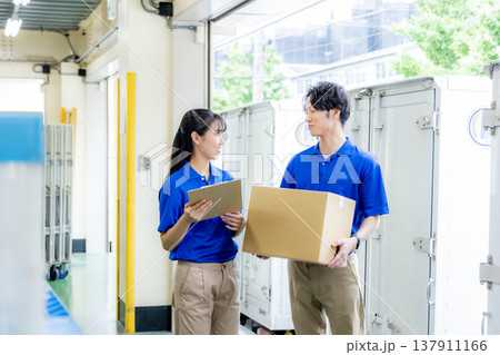 荷物を届ける宅急便の男女 荷物を届ける宅急便の男女 137911166