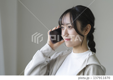 スマートフォンで通話する笑顔の若い女性 137911870