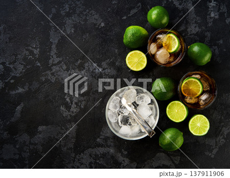 Glasses of tasty Cuba Libre cocktail on dark wooden background, top view. 137911906