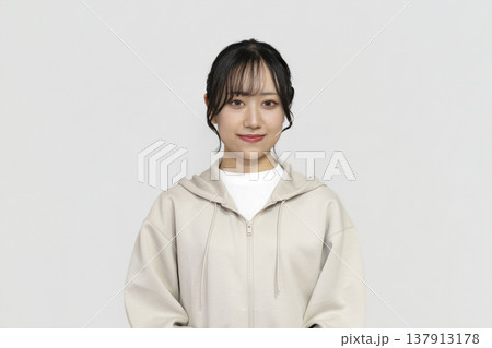 カメラ目線で微笑む若い女性　白背景ポートレート 137913178