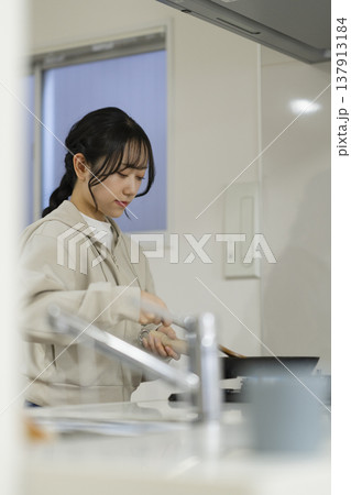 キッチンで料理をする若い女性　 137913184