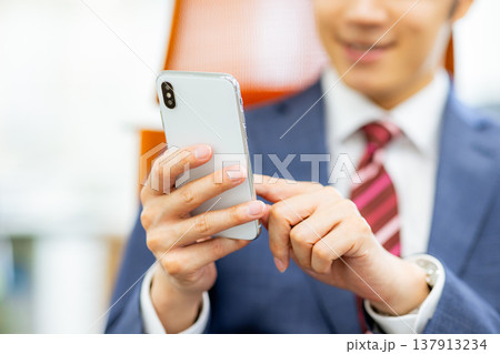 スマートフォンを操作するビジネスマン スマートフォンを操作するビジネスマン 137913234