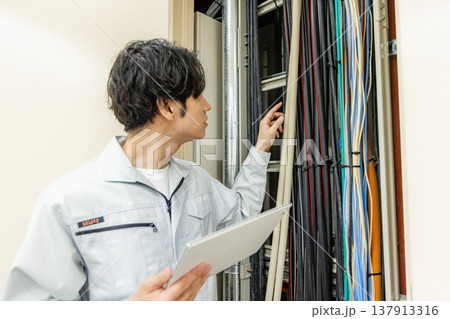 工場内の配電盤を操作する男性 工場内の配電盤を操作する男性 137913316